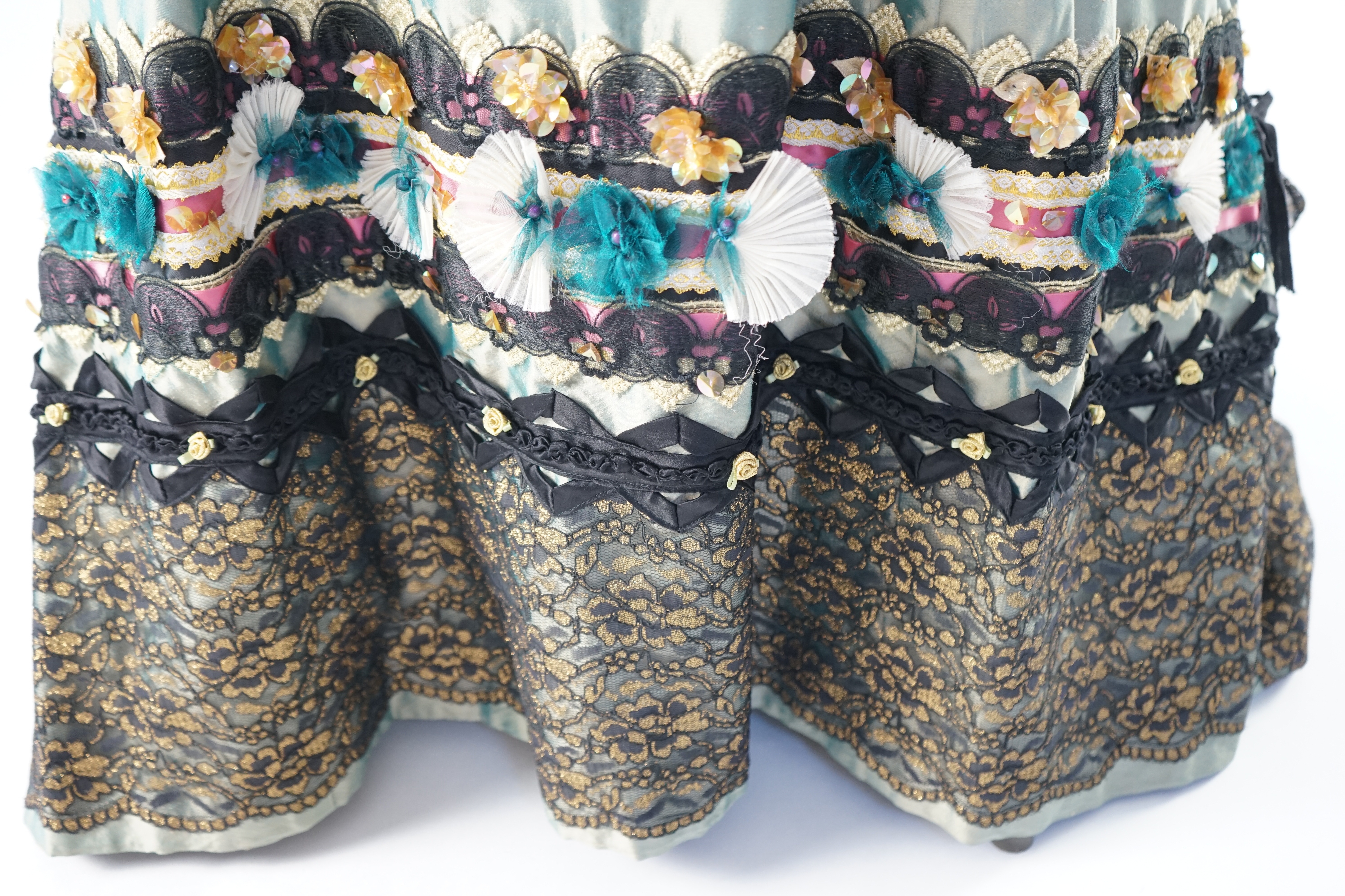An Edwardian style lady's green taffeta skirt decorated with beaded, sequinned, ribboned border and swags of silk velvet, together with matching train layered with frilled black and gold lace, appliquéd with gold bows